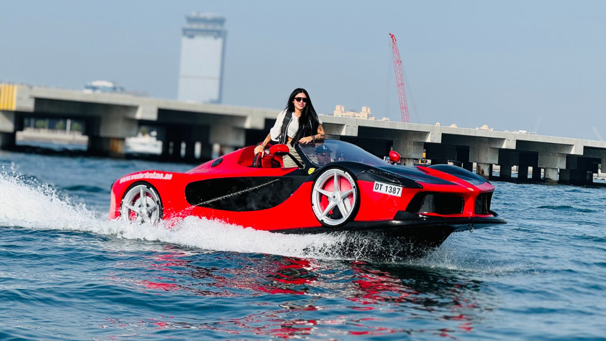 Woman driving a red jet car across the water during a Dubai water sports experience