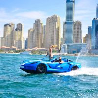 Couple enjoying blue jet car ride near Dubai Marina skyline